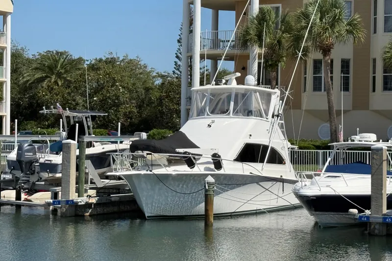 The Image of 1997 Ocean Yachts 40 Super Sport docked at marina with palm trees in background. - 1