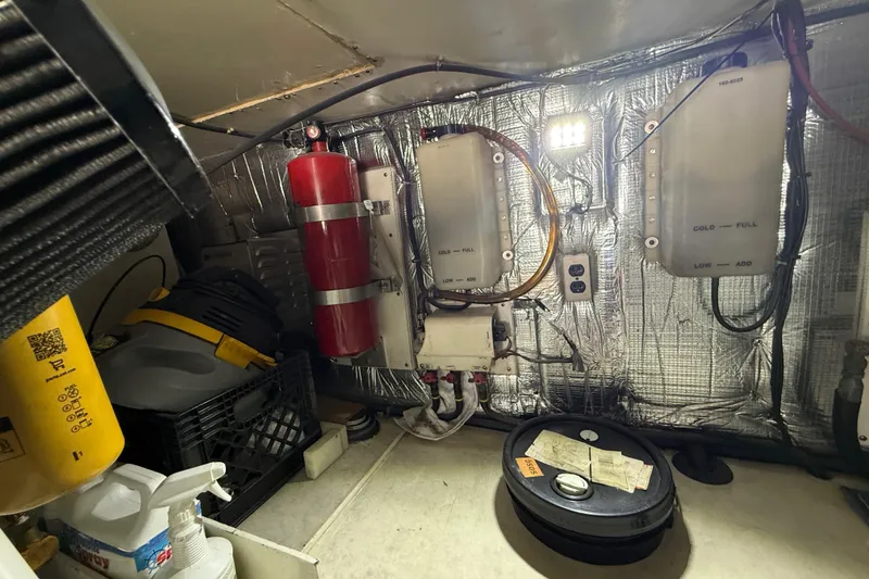 Slide: The Image of Engine room of 1997 Ocean Yachts 40 Super Sport with equipment and fire extinguisher. - 31