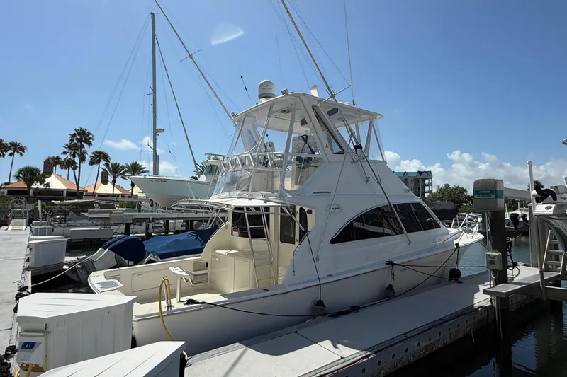 Slide: The Image of 1997 Ocean Yachts 40 Super Sport docked at marina under clear blue sky. - 4