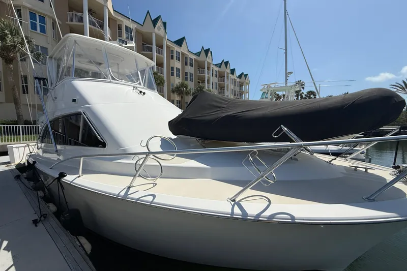 Slide: The Image of 1997 Ocean Yachts 40 Super Sport docked near waterfront buildings under clear sky. - 6