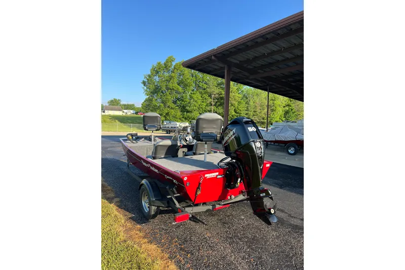 Slide: The Image of 2026 Tracker Bass Tracker Classic XL boat with Mercury engine, parked outdoors. - 3