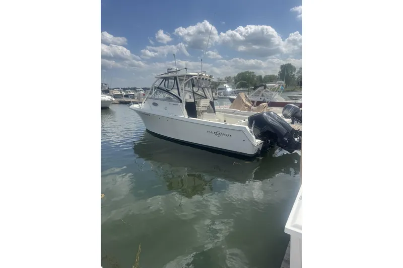 The Image of 2007 Sailfish 2660 WAC boat docked in a marina under a partly cloudy sky. - 0