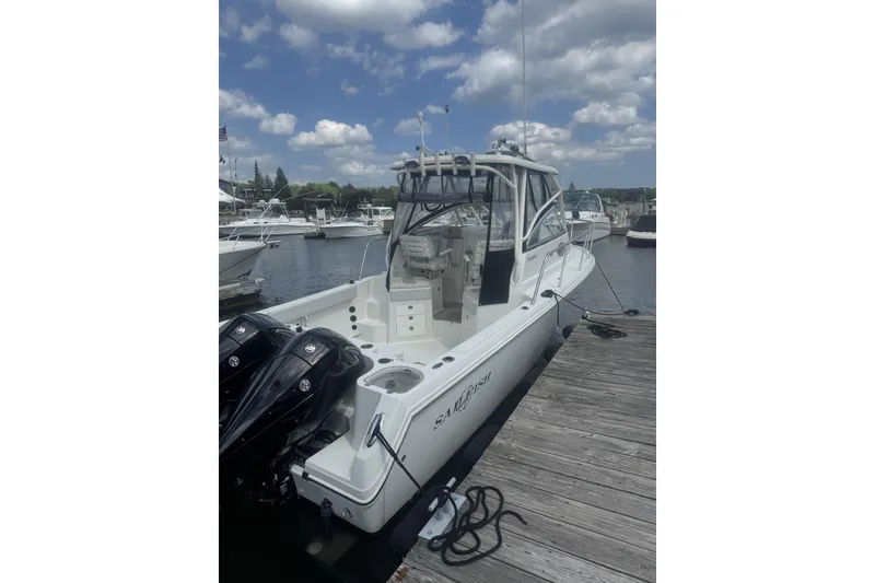 Slide: The Image of 2007 Sailfish 2660 WAC boat docked at marina under cloudy sky. - 2