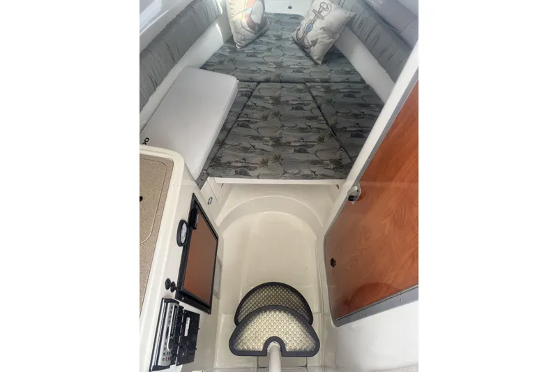 Slide: The Image of 2007 Sailfish 2660 WAC cabin interior with patterned cushions and wooden door. - 22