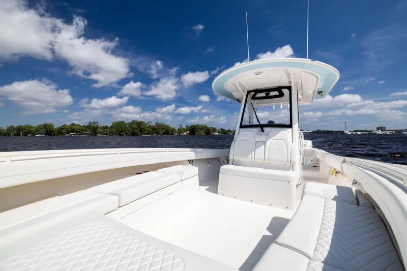 Slide: The Image of 2024 Regulator 34 boat with white seating, on a sunny day, under a blue sky. - 18