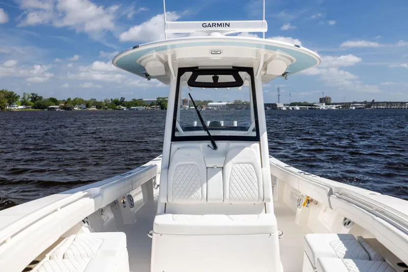 Slide: The Image of 2024 Regulator 34 boat on water, featuring Garmin equipment, clear skies, and scenic shoreline. - 19