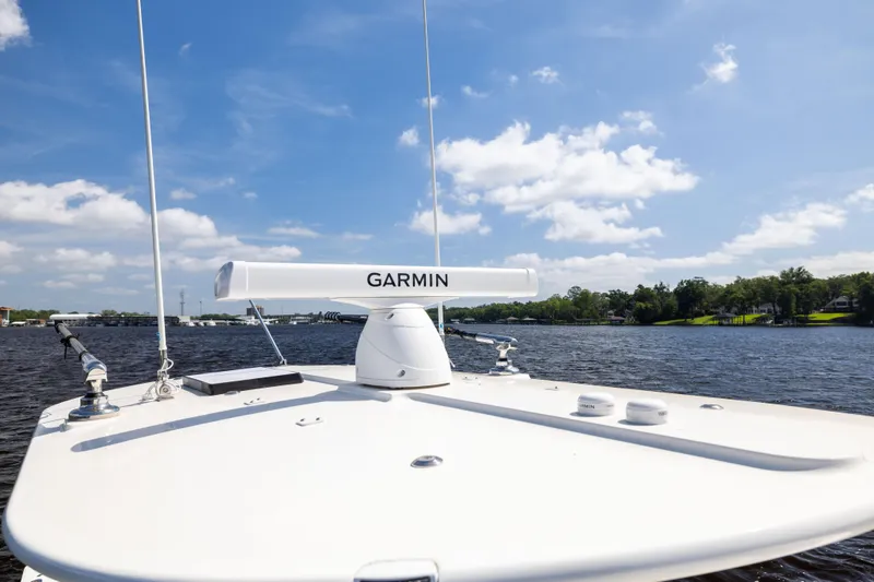 Slide: The Image of 2024 Regulator 34 boat with Garmin radar on calm water under blue sky. - 21