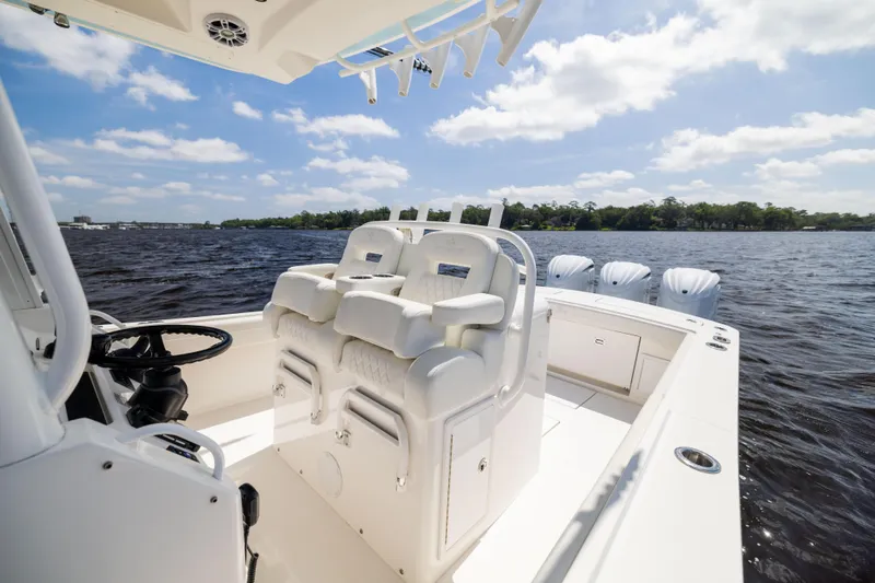 Slide: The Image of 2024 Regulator 34 boat interior with luxurious seating and multiple outboard engines on a sunny day. - 28