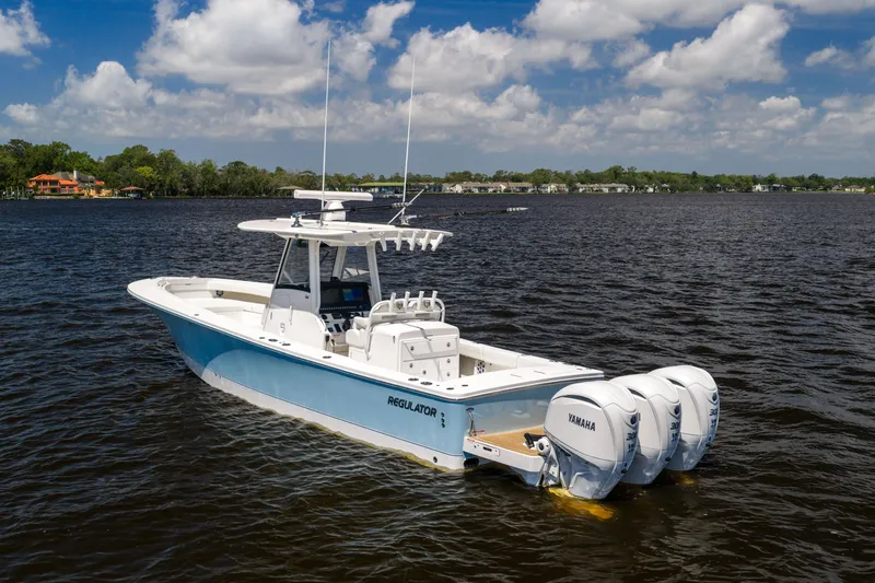 Slide: The Image of 2024 Regulator 34 boat with Yamaha engines on a sunny day, calm waters. - 3