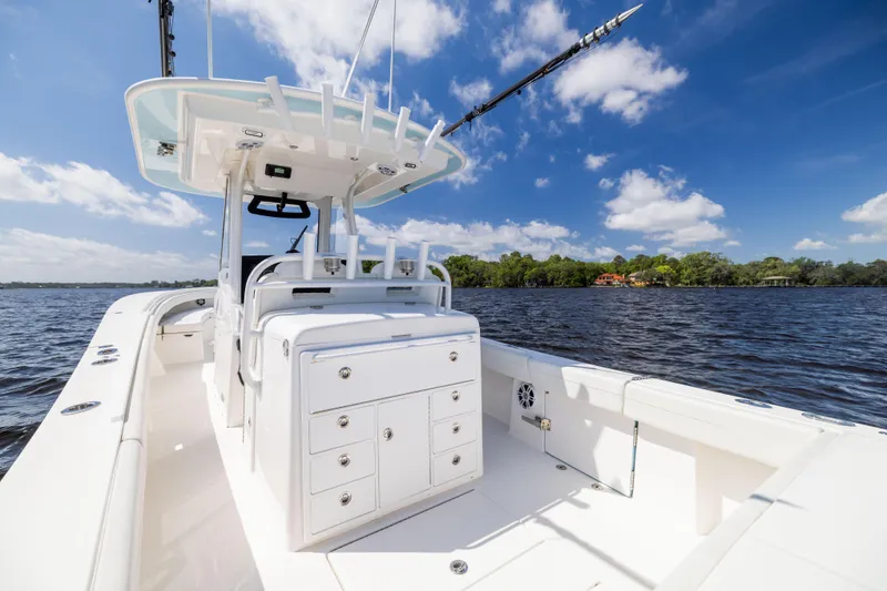 Slide: The Image of 2024 Regulator 34 boat on water, featuring spacious deck and clear blue sky. - 32