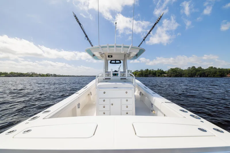 Slide: The Image of 2024 Regulator 34 boat on open water under a clear blue sky. - 33
