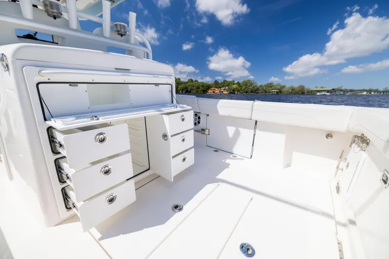 Slide: The Image of 2024 Regulator 34 boat interior with open storage drawers, under a clear blue sky. - 35