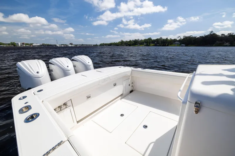 Slide: The Image of 2024 Regulator 34 boat with triple outboard engines on a sunny day. - 38