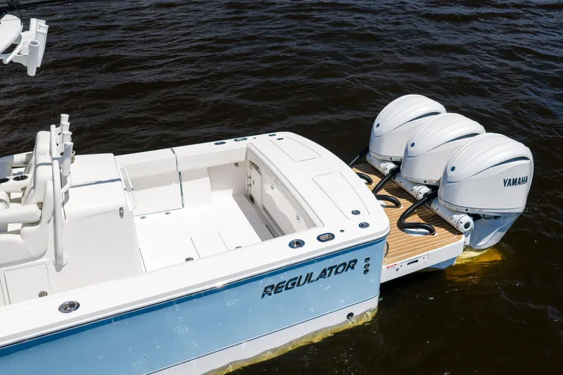 Slide: The Image of 2024 Regulator 34 boat with triple Yamaha engines on water. - 4