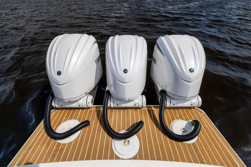 Slide: The Image of Triple Yamaha outboard engines on 2024 Regulator 34 boat, docked on water. - 44