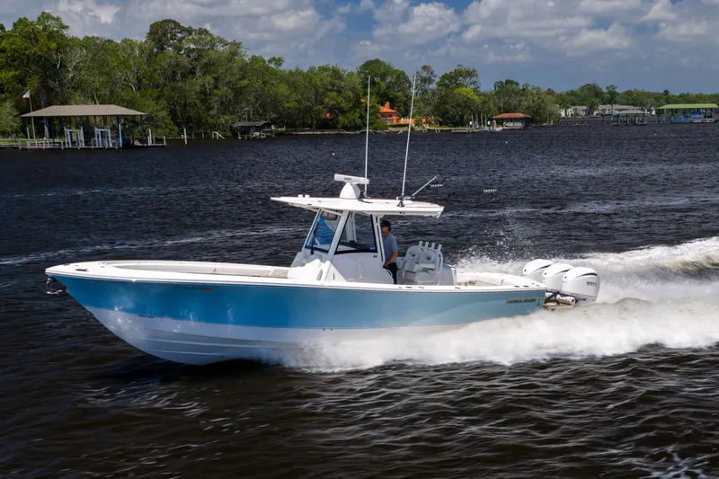 Slide: The Image of 2024 Regulator 34 boat cruising on a river under a partly cloudy sky. - 8