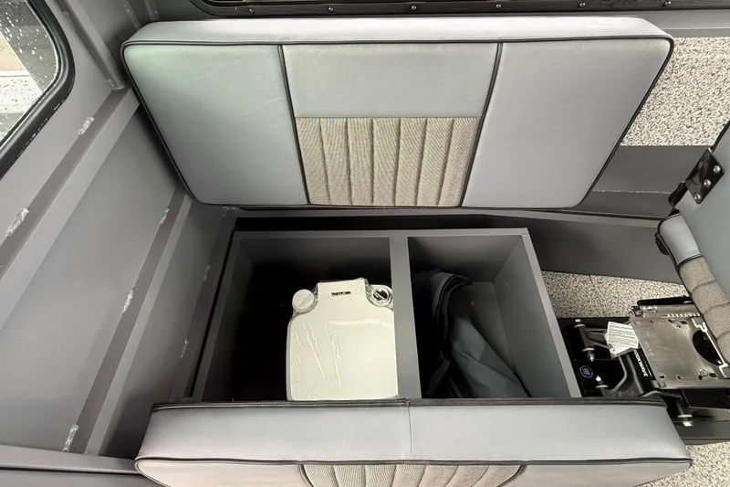Slide: The Image of 2026 Alumaweld Intruder 22 HT interior storage compartment with gray upholstery and organized space. - 13