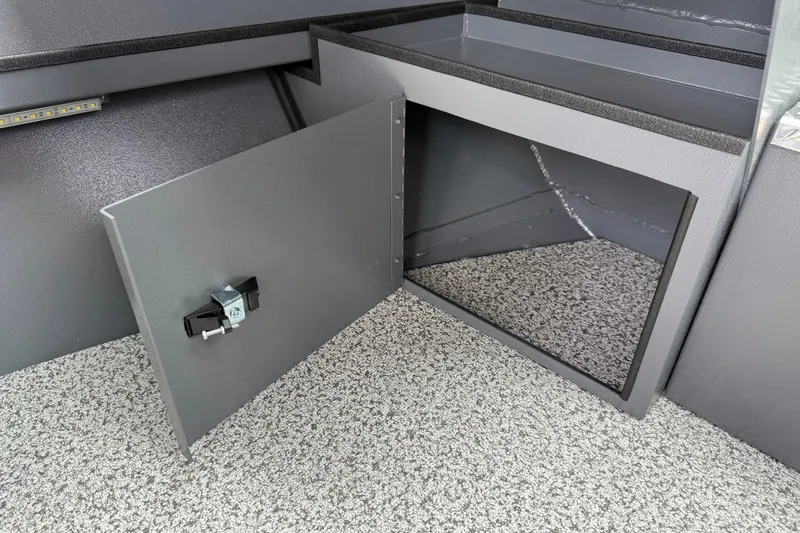 Slide: The Image of Open storage compartment in 2026 Alumaweld Intruder 22 HT boat, featuring secure latch and carpeted interior. - 19