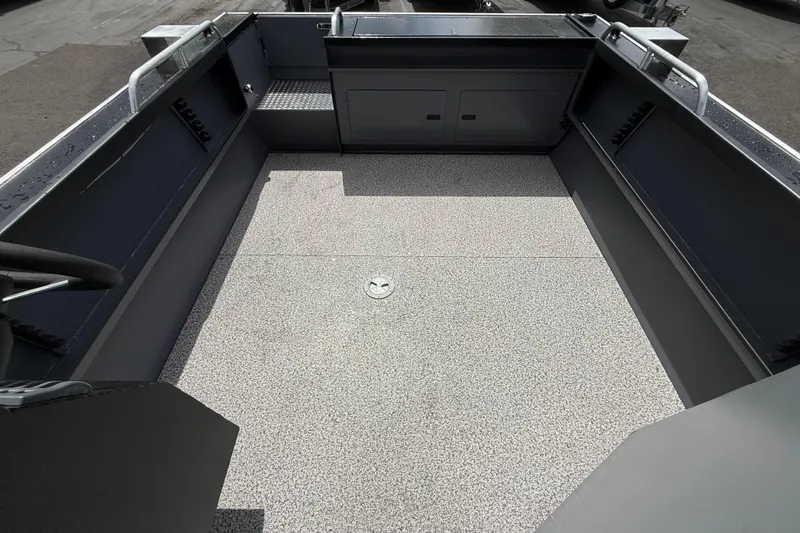 Slide: The Image of 2026 Alumaweld Intruder 22 HT boat interior with spacious, textured deck and storage compartments. - 23
