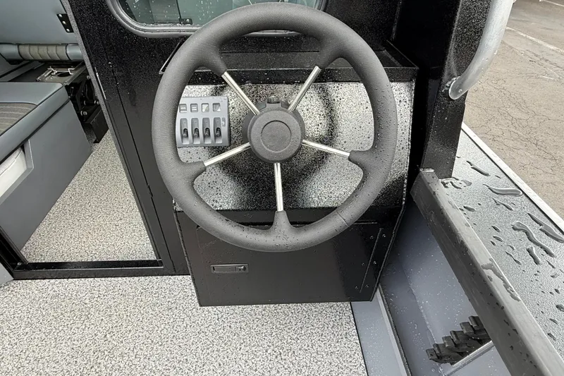 Slide: The Image of Steering wheel of 2026 Alumaweld Intruder 22 HT boat, featuring control panel and sleek design. - 24