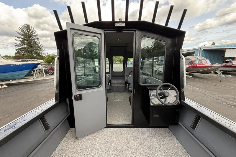 Slide: The Image of 2026 Alumaweld Intruder 22 HT boat interior with open cabin door, steering wheel visible. - 3