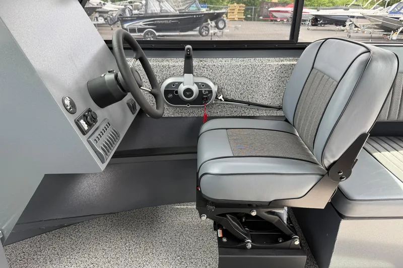 Slide: The Image of 2026 Alumaweld Intruder 22 HT boat interior with steering wheel and cushioned seat. - 6