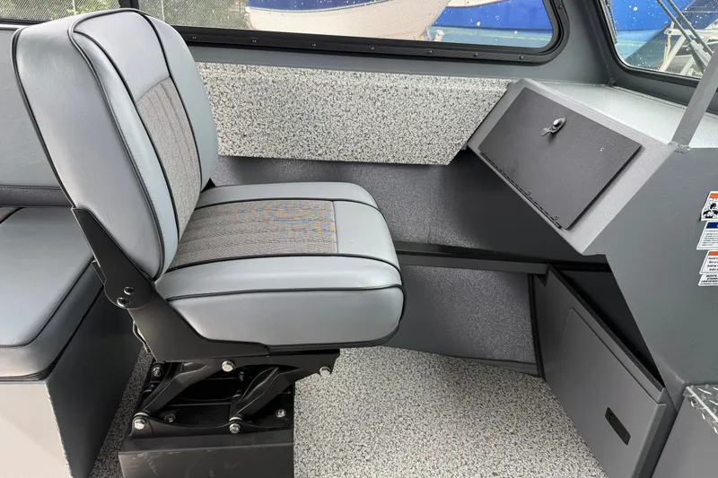 Slide: The Image of Interior of 2026 Alumaweld Intruder 22 HT boat, featuring a cushioned seat and storage compartment. - 8