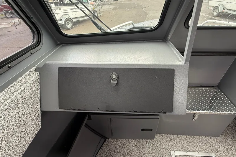 Slide: The Image of 2026 Alumaweld Intruder 22 HT interior dashboard with storage compartment and windows. - 9