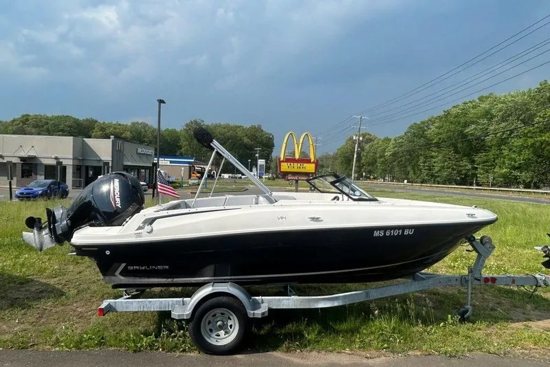 The Image of 2023 Bayliner VR4 Bowrider OB on trailer, parked near roadside with McDonald's sign. - 0