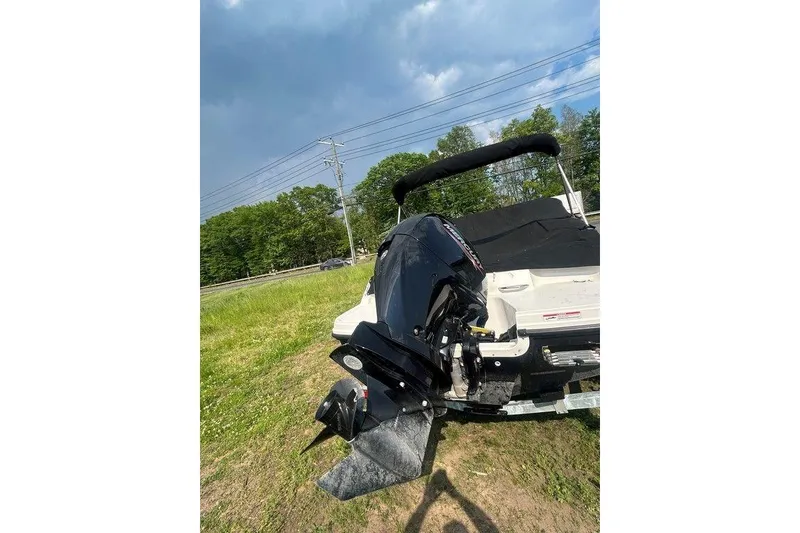 Slide: The Image of 2023 Bayliner VR4 Bowrider OB with outboard motor on grassy area. - 2