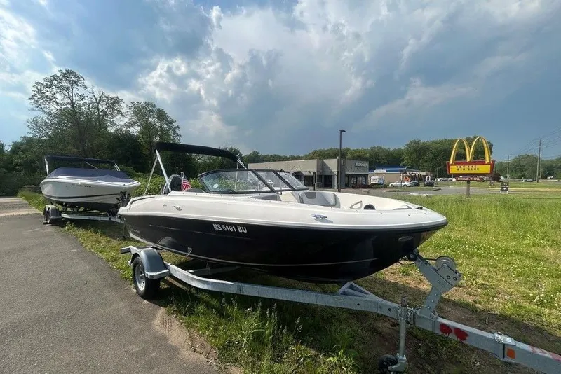 Slide: The Image of 2023 Bayliner VR4 Bowrider OB on trailer, parked near roadside with McDonald's sign. - 3