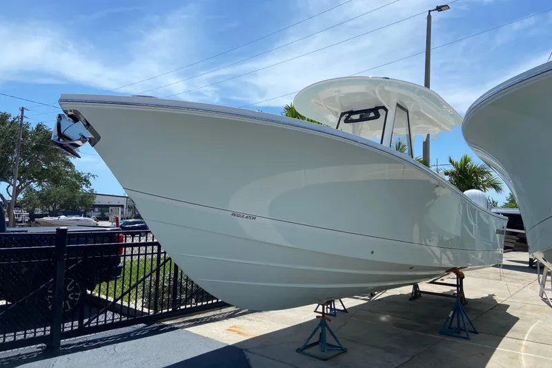 The Image of 2026 Regulator 31 boat displayed outdoors on stands under a clear blue sky. - 0