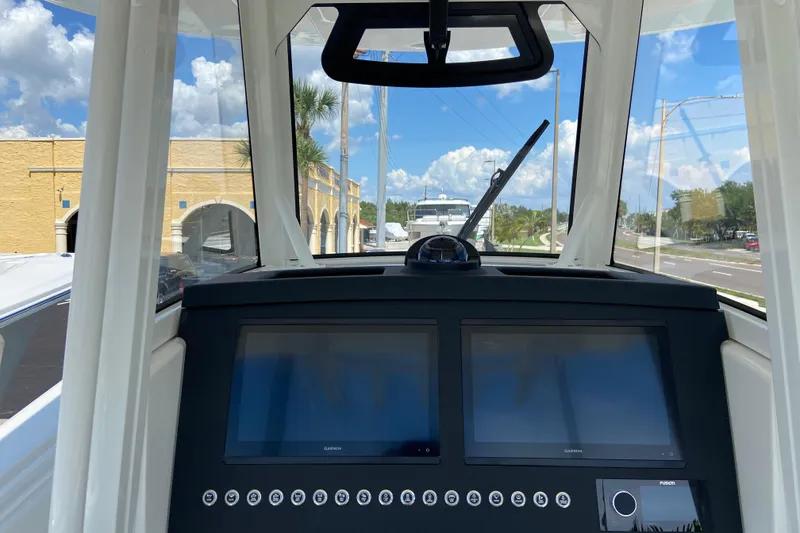 Slide: The Image of 2026 Regulator 31 boat dashboard with dual Garmin screens and clear windshield view. - 24