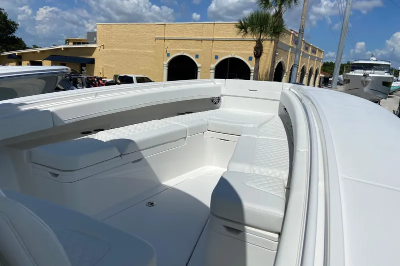 Slide: The Image of 2026 Regulator 31 boat interior with white seating, docked near a yellow building. - 30