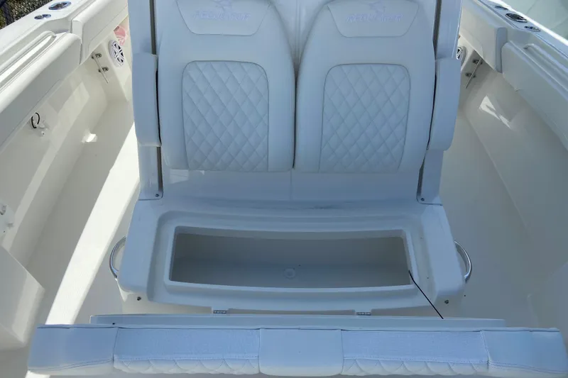 Slide: The Image of 2026 Regulator 31 boat interior with white cushioned seating and storage compartment. - 42