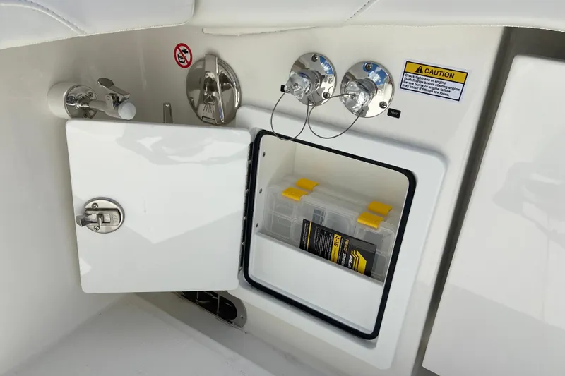 Slide: The Image of 2026 Regulator 31 boat storage compartment with safety warning and utility access. - 5