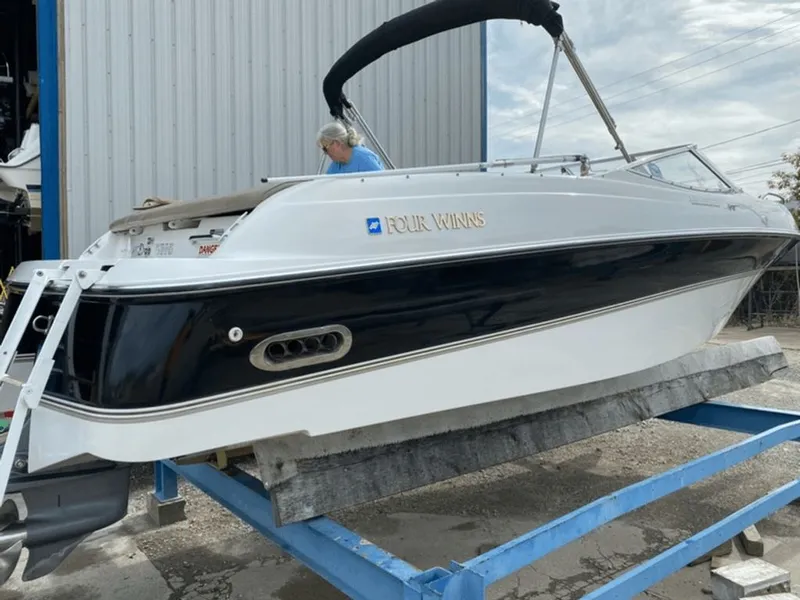 Slide: The Image of 1998 Four Winns 240 Horizon boat on a blue stand. - 16