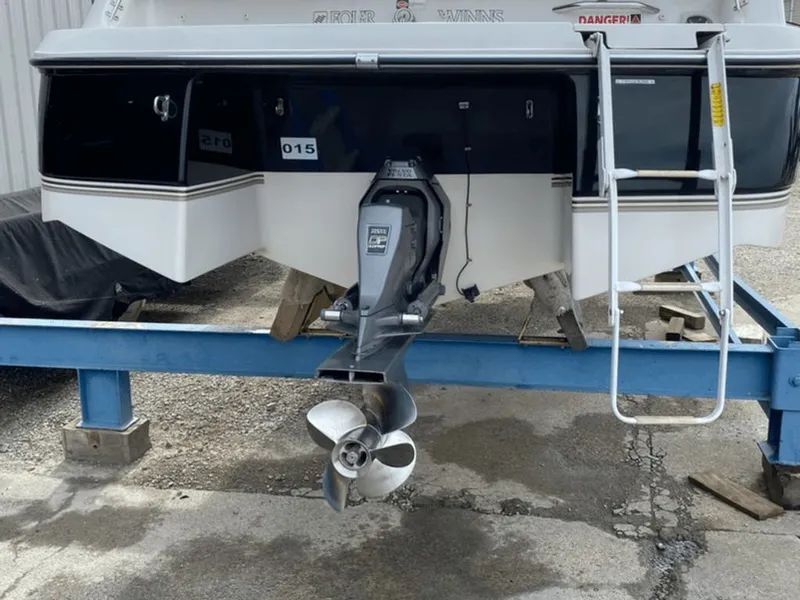 Slide: The Image of Rear view of a 1998 Four Winns 240 Horizon boat on a stand. - 18