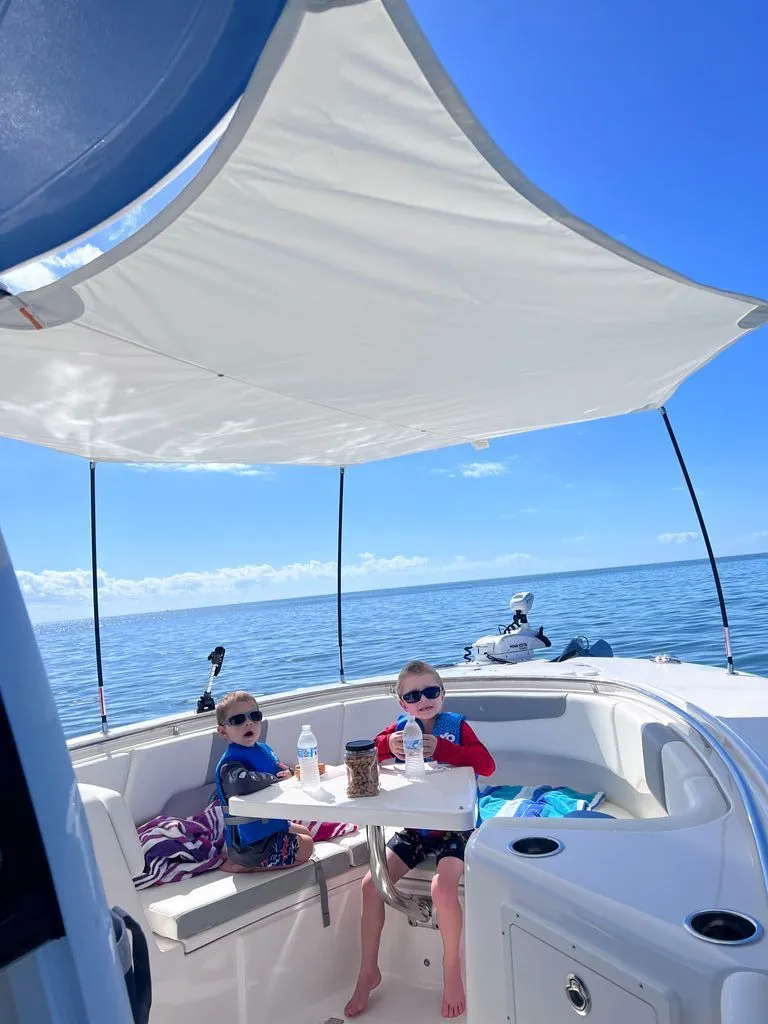 Slide: The Image of Children enjoying a boat ride on a 2023 Robalo R302 Center Console. - 15