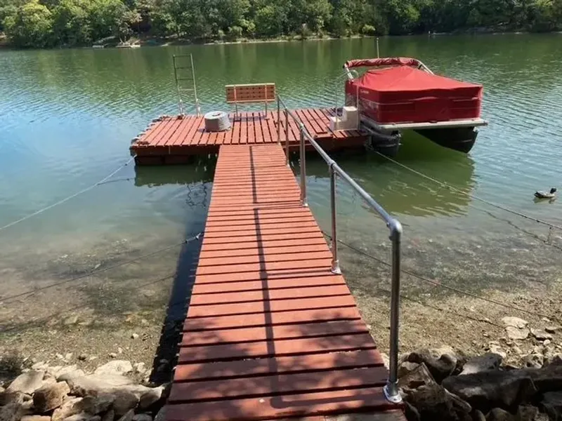 Slide: The Image of 2014 Sun Tracker Bass Buggy docked at a wooden pier on a tranquil lake. - 13