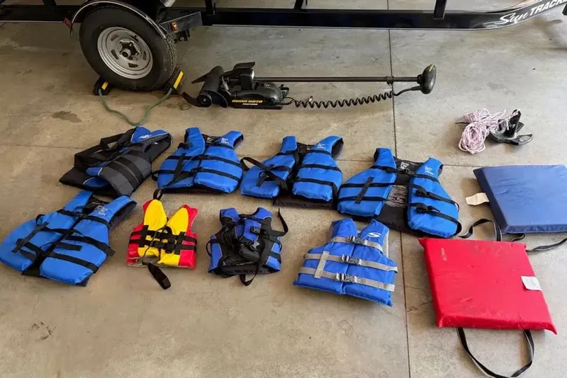 Slide: The Image of Various life jackets and accessories beside a 2014 Sun Tracker Bass Buggy. - 16