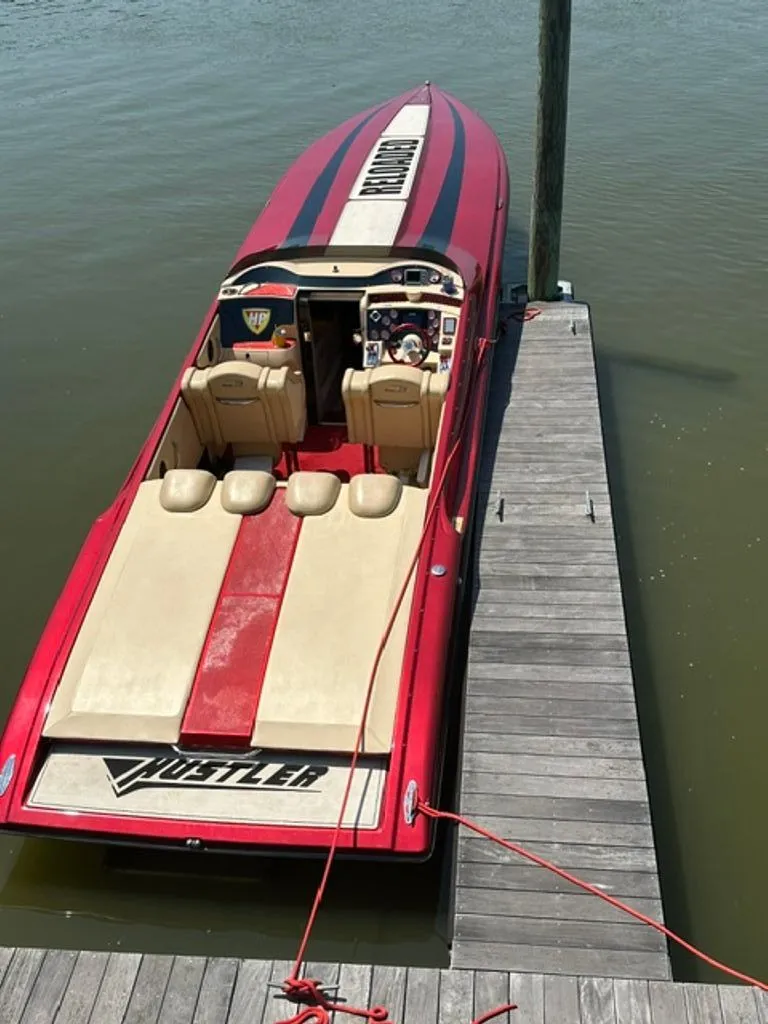 Slide: The Image of 2016 Hustler Slingshot boat docked, red and beige design. - 24