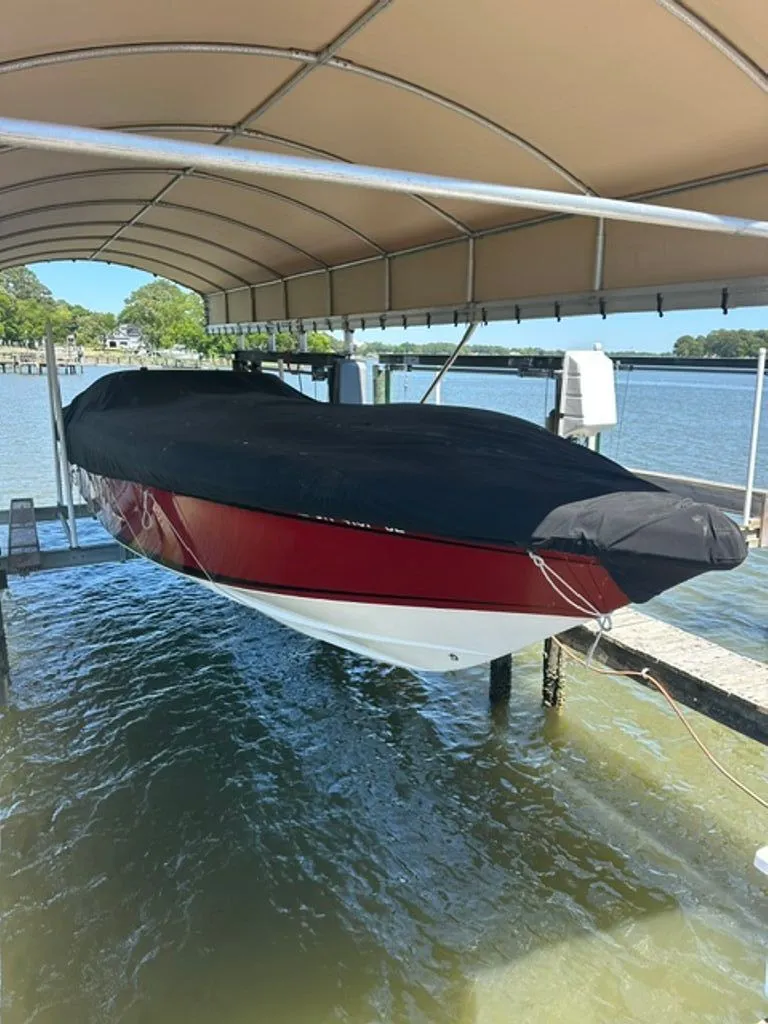 Slide: The Image of 2016 Hustler Slingshot boat with cover on a boat lift. - 27