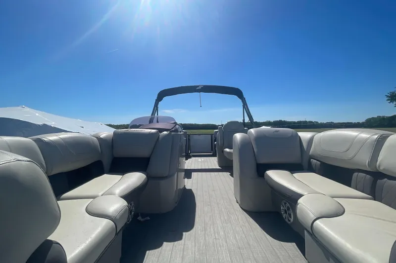 Slide: The Image of 2019 Starcraft SLS 1 pontoon boat interior with spacious seating under clear blue sky. - 3