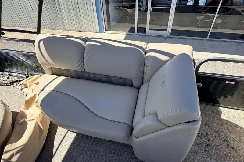 Slide: The Image of 2017 Manitou 25 SES BENCH with beige seating on a boat deck. - 4