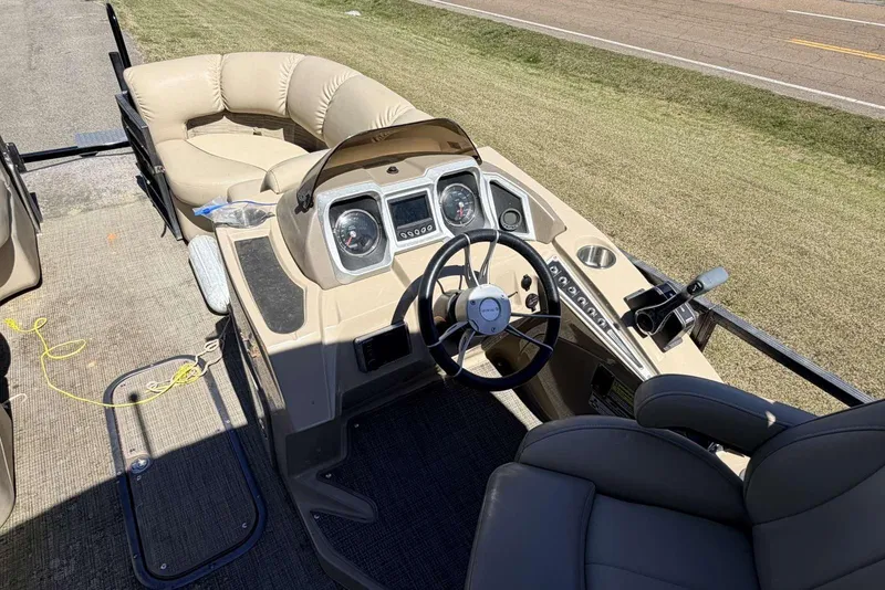 Slide: The Image of 2017 Manitou 25 SES BENCH boat interior with steering console and seating. - 6