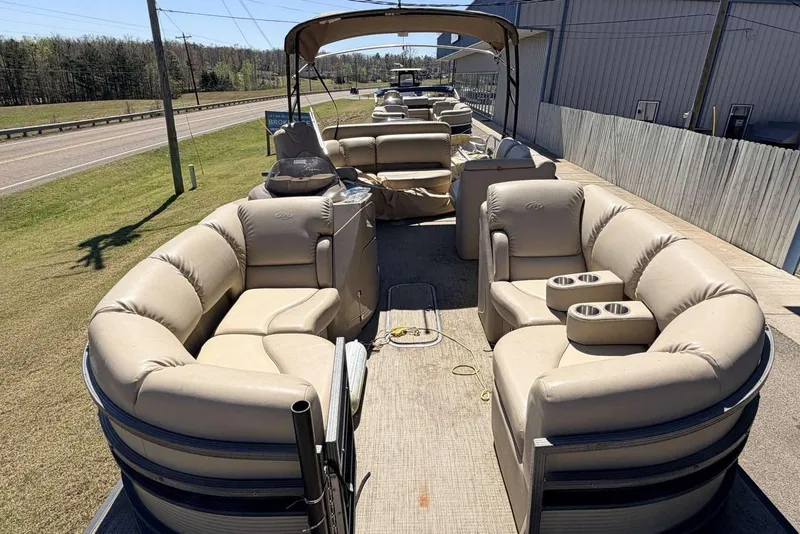 Slide: The Image of 2017 Manitou 25 SES BENCH pontoon boat with beige seating and cup holders. - 7