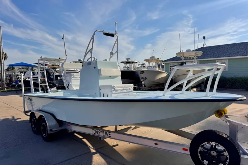 The Image of 2023 Waterman Wildwater 23 boat on trailer, displayed outdoors under a clear sky. - 0