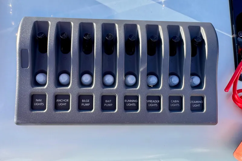 Slide: The Image of Control panel of Waterman Wildwater 23 boat, featuring various light and pump switches. - 13