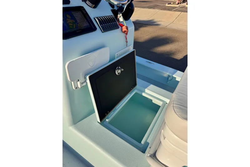 Slide: The Image of Interior view of a 2023 Waterman Wildwater 23 boat, featuring an open storage compartment. - 19
